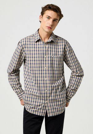 Camisa de cuadros en mezcla de algodón, con una base beige y un patrón de cuadros en azul y rojo, cierre de botones en la parte delantera, mangas largas y un bolsillo en el pecho.