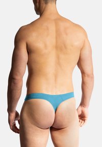 Tealfarbene Herren-Slips aus einer weichen Baumwollmischung, mit minimalistischem Design und elastischem Bund, von hinten betrachtet.
