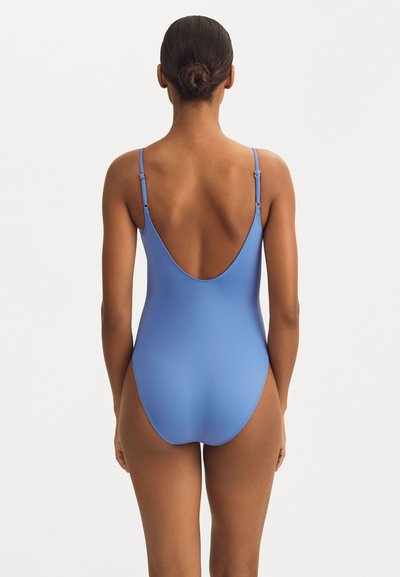 Maillot de bain une pièce bleu avec de fines bretelles réglables, une conception de dos décolleté, une texture lisse et une silhouette ajustée.