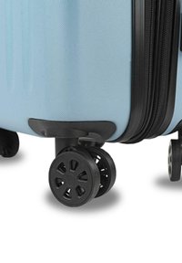 Maleta dura azul con una superficie texturizada, dos ruedas negras con un diseño de radio y un borde de cremallera negra.