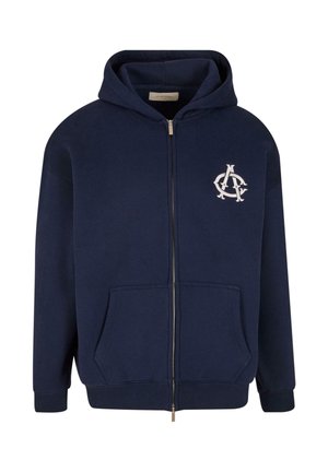Navy blue zip-up hoodie made of cotton blend, featuring a front pocket and a white logo accent on the left chest area. Soft texture.