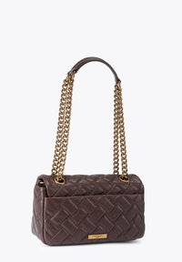 Brązowa pleciona skórzana torba na ramię z złotymi łańcuszkowymi paskami, o prostokątnym kształcie, z metalową, markową blaszką z przodu. Detal o fakturowanej powierzchni.