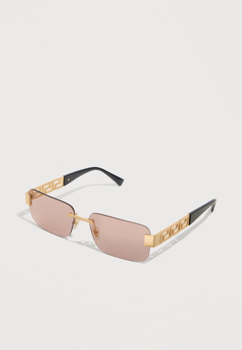 Αγυάλια ορθογώνιου σχήματος χωρίς πλαίσιο με ροζ φακούς, χρυσά γεωμετρικά διακοσμημένα πλαϊνά και μαύρες άκρες σε λευκό φόντο.