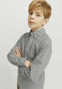 Camicia a quadri grigia e bianca con maniche lunghe, dotata di colletto e taschino sul petto. Tessuto di cotone liscio.