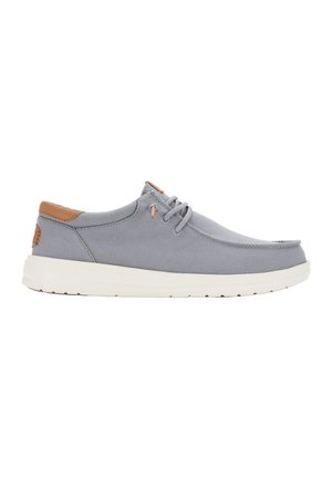 Scarpa in tela grigia con punta tonda, dettagli in pelle beige e suola leggera e ammortizzata. Presenta lacci e una parte superiore testurizzata.