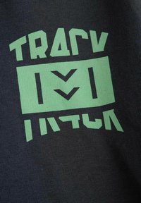 Czarny bawełniany T-shirt z wyrazistym zielonym napisem graficznym. Projekt zawiera geometryczne kształty i abstrakcyjne wzory o różnej grubości linii.