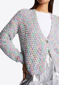 Pastel-colored cardigan features a textured, knitted design with a button closure, displaying shades of pink, green, and blue.
