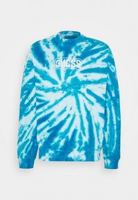 Sudadera azul claro con diseño tie-dye que presenta un patrón circular, cuello redondo acanalado y el logotipo bordado en blanco "GUESS" en el pecho.