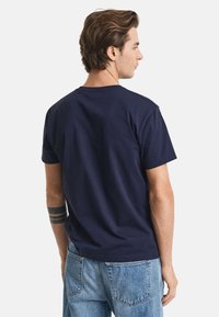 Camiseta de algodón azul marino con escote redondo clásico y mangas cortas, que presenta una textura suave y un corte cómodo.