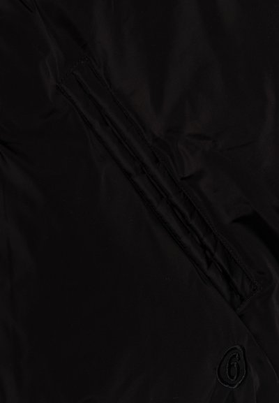 Stof negru cu o fanta verticala si un numar mic brodat "6" aproape de colțul din dreapta jos.