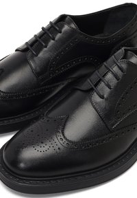 Zwarte leren schoenen met een klassiek wingtip-design, geperforeerde details en een ronde neus, met een gladde afwerking en vetersluiting.