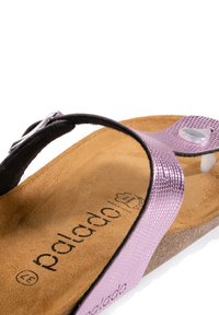 Lila metallisk sandal med en texturerad rem, läderfotsäng och korksula. Inkluderar en silverfärgad spänne och logotyp på fotsäng.