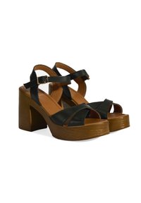 Schwarze Leder-Plateausandalen mit Kreuzriemen, verstellbarem Knöchelriemen und einem braunen Holzblockabsatz. Glatte Textur und offenes Zehendesign.