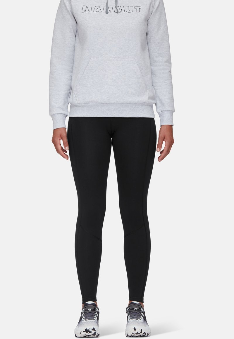 Black leggings with a fitted design, paired with a gray sweatshirt featuring a logo, worn with gray and white athletic shoes.