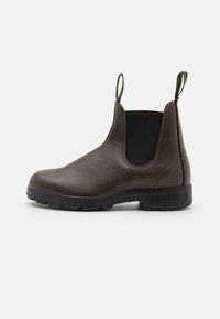 Bottine Chelsea en cuir marron avec des panneaux élastiques sur les côtés, des anses en haut et une semelle en caoutchouc durable, présentant une finition lisse.