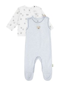 Zweiteiliges Baby-Outfit: Ein weißes Langarmoberteil mit Tiermotiven und eine blaue ärmellose Latzhose mit einem Bären-Patch und Fußdesign.