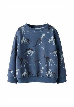 Blå børnetrøje med forskellige dinosaur-skeletmønstre i hvidt og sort, med lange ærmer og ribkant ved ærmer og talje.