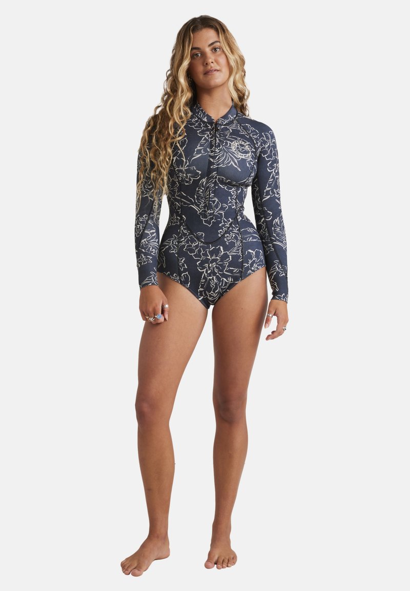 Dlouhý rukáv, tmavě modrý rash guard plavky s květinovými bílými vzory, vysoký límec a zapínání na zip. Vyrobeno z elastického, na plavání vhodného materiálu.
