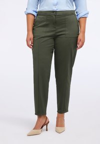 Pantaloni a sigaretta verde oliva in cotone, con tasche laterali, una texture liscia e chiusura anteriore con bottone.