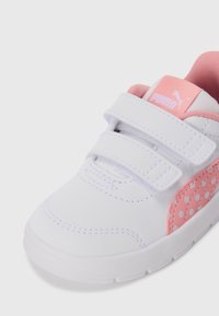 Baskets pour tout-petit blanches et roses avec des bandes velcro, détail latéral à pois roses et logo Puma sur la languette.