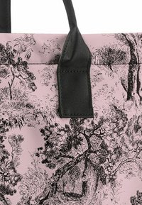 Rosa Stofftasche mit schwarzen Illustrationen von Bäumen und Landschaften, ausgestattet mit einem stabilen schwarzen Tragegriff. Robuste und strukturierte Oberfläche.