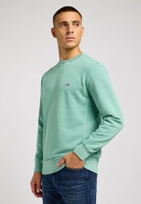 Miętowa bluza crewneck wykonana z miękkiego materiału, z ribbowanymi mankietami i dołem, z małym czarnym logo "Lee" z przodu.