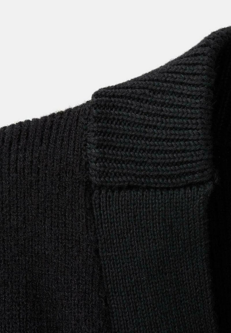 Zwarte gebreide sweaterstof met een geribde kraag en een gestructureerd oppervlak. Toont een close-up van de weefsel en stiksel details van de stof.