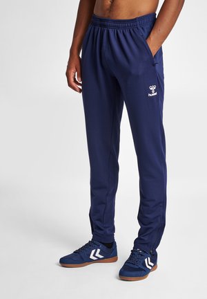 Navyblaue Sporthose mit einem elastischen Bund, Seitentaschen und einem kleinen weißen Logo. Das Material hat eine strukturierte Oberfläche für zusätzlichen Halt.