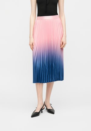 Femme portant une jupe midi plissée dégradée du rose au bleu, associée à un haut noir sans manches et des escarpins noirs à bouts pointus et bride arrière.