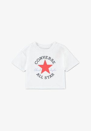Tricou alb scurt, decupat, cu mâneci scurte, având o stea roșie mare și textul „CONVERSE ALL STAR” în negru, cu „Chuck Taylor” în albastru deschis.