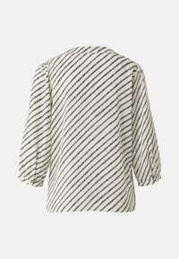 Blouse blanche avec un motif diagonal noir, manches bouffantes 3/4, tissu doux et encolure arrondie. Vue de dos affichée.