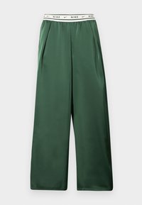 Πράσινο παντελόνι με φαρδιά μπατζάκια και ελαστική ζώνη μέσης, με επαναλαμβανόμενο μαύρο κείμενο "NIKE" και λογότυπα swoosh σε λευκό φόντο.