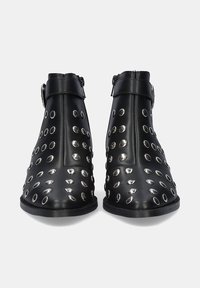 Botas de tobillo negras de cuero con punta redonda. Presenta acentos de ojales plateados y una hebilla lateral para el cierre. Suela plana.