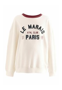 Sudadera crema con cuello burdeos y puños acanalados. Presenta "LE MARAIS ATHL CLUB PARIS" en letras negras y burdeos. Corte casual.
