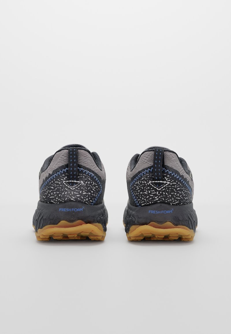 Zapatillas deportivas en gris oscuro con parte superior de malla texturizada, suela de goma y acentos en azul claro. Cuenta con un tirador en el talón y la marca "FRESH FOAM".