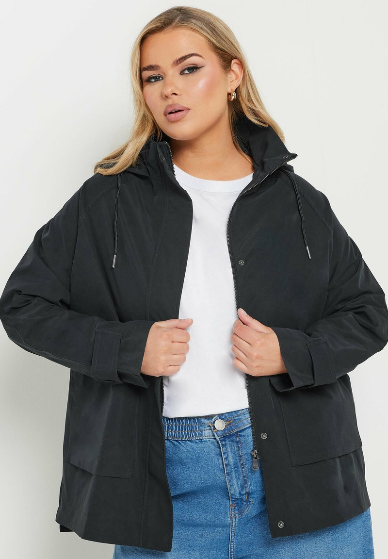 Svart vattentät jacka med huva, framdragkedja och tryckknappar. Har långa ärmar och stora framfickor. Slät textur.