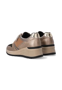 Beige und metallische Sportschuhe mit einer strukturierten Oberfläche, Reißverschluss und schwarzen Gummisohlen. Erhöhtes Keil-Design für zusätzlichen Komfort.