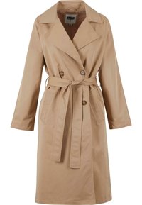 Trench-coat beige longueur genoux avec larges revers, boutons croisés, deux poches avant et ceinture nouée à la taille.