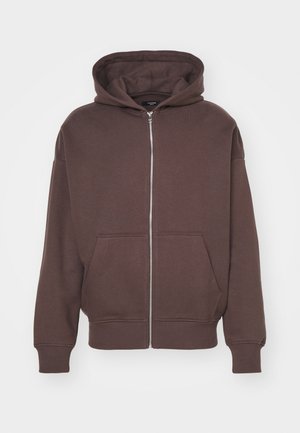 Sudadera con capucha marrón con cremallera, capucha con cordón, bolsillos delanteros y puños acanalados. Fabricada en un suave material de jersey con acabado texturizado.