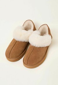 Brown suede slippers with a fluffy cream-colored fur cuff, flat soles, and stitched detailing, suitable for indoor wear.