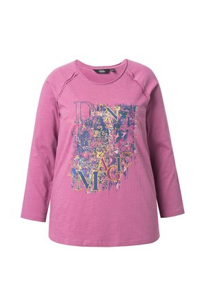 Roze langesleeve shirt met een ronde halslijn. De voorkant heeft een grafische print met kleurrijke tekst "DANCE MAGIC" in abstracte patronen en texturen.