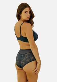Soutien-gorge en dentelle marine et culottes taille haute avec des accents en maille transparente, motif floral et bretelles réglables, présentant une finition lisse.
