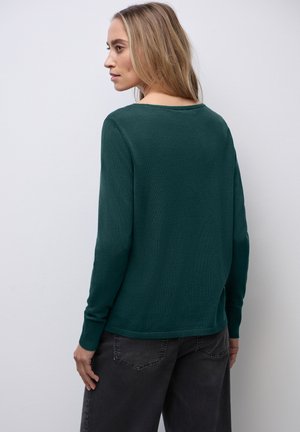 Maglione verde a maglia con maniche lunghe, colletto rotondo e polsini a coste. Il tessuto appare liscio e leggero, con una vestibilità comoda.