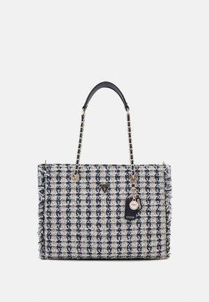 Tweed rektangulær håndtaske med sort-hvid ternet mønster, kæde- og læderhåndtag samt vedhæftede GUESS-mærketags.