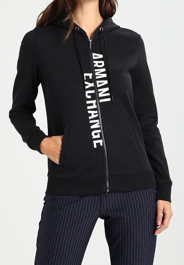 Felpa nera con zip realizzata in tessuto morbido, dotata di tasca a marsupio frontale e logo bianco "ARMANI EXCHANGE" che corre in verticale.