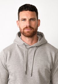 Grijze hoodie van zacht materiaal met een voorzak en trekkoorden. Kenmerkt zich door een ontspannen pasvorm en geribbelde manchetten voor comfort.