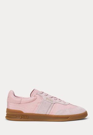 Lichtroze lage sneaker met rubberen zool en "Polo"-branding aan de zijkant en op de tong, gezien vanaf de binnenkant.