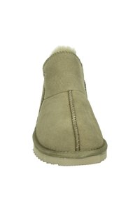 Botines de ante verde con forro suave, detalle de costura visible y suela de goma. Diseño simple con punta redondeada.