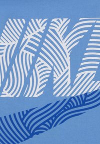 Ανοιχτό μπλε μπλουζάκι με γραφικό σχέδιο σε λευκές και σκούρες μπλε ρίγες που μοιάζει με φύλλα φυτού. Το υλικό φαίνεται μαλακό και βαμβακερό.