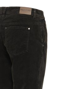 Jean en denim noir avec poche arrière et étiquette de marque en cuir portant la mention "Pulz Jeans" sur la ceinture.